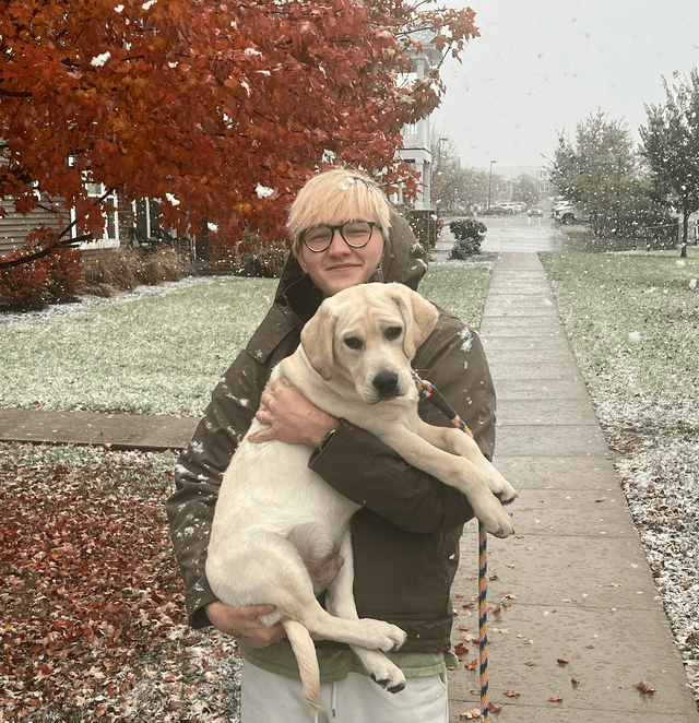 Parker Johnson - Web Developer and ASU Graduate from Waukee Iowa holding a yellow Labrador puppy in the snow